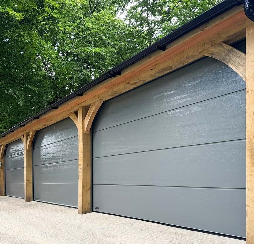 Grey Teckentrup CarTeck sectional doors in timber-framed garage openings
